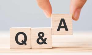 hand holding q and a word with wooden cube block. faq( frequency asked questions), answer, question ask, information, communication and brainstorming concepts